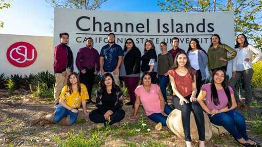 A group of people posing in front of a CSU Channel Islands entrance sign